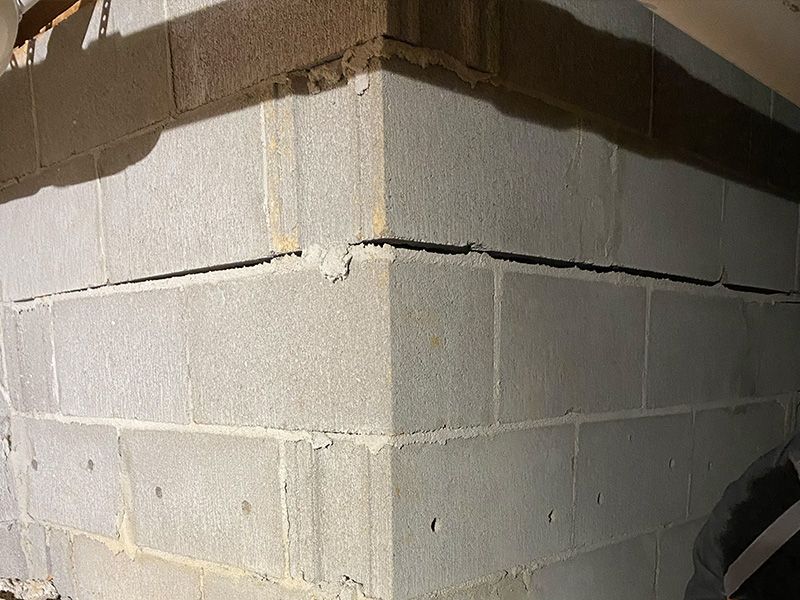 a large horizontal crack in the seam of a cinderblock wall