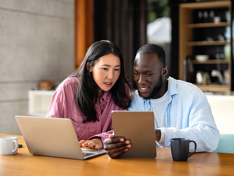 A couple using a computer and a tablet to examine their goals
